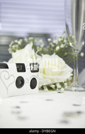 Einweg-weiße Hochzeit Kamera auf einer Hochzeitstafel. Stockfoto