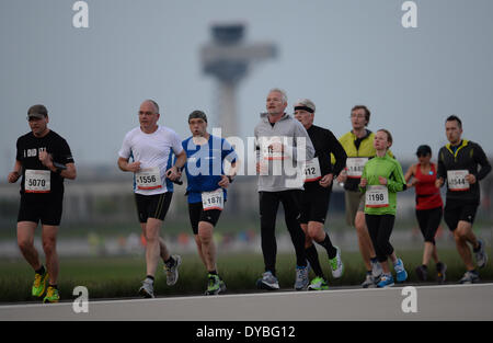 Schönefeld, Deutschland. 12. April 2014. Teilnehmer des 8. Airport Night Run laufen auf dem Gelände des Flughafen Berlin Brandenburg International (BER) in Schönefeld, Deutschland, 12. April 2014. Foto: Ralf Hirschberger/Dpa/Alamy Live News Stockfoto