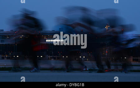 Schönefeld, Deutschland. 12. April 2014. Teilnehmer des 8. Airport Night Run laufen auf dem Gelände des Flughafen Berlin Brandenburg International (BER) in Schönefeld, Deutschland, 12. April 2014. Foto: Ralf Hirschberger/Dpa/Alamy Live News Stockfoto