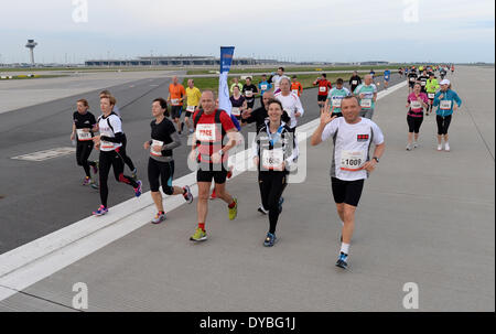 Schönefeld, Deutschland. 12. April 2014. Teilnehmer des 8. Airport Night Run laufen auf dem Gelände des Flughafen Berlin Brandenburg International (BER) in Schönefeld, Deutschland, 12. April 2014. Foto: Ralf Hirschberger/Dpa/Alamy Live News Stockfoto