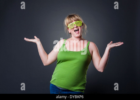 Glückliche junge schwangere Frau im Studio - dunklen Hintergrund Stockfoto