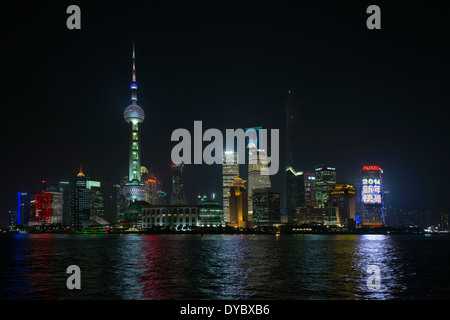 Pudong-Skyline bei Nacht mit Reflexionen in den Huangpu-Fluss, entnommen aus dem Bund, Shanghai, China Stockfoto