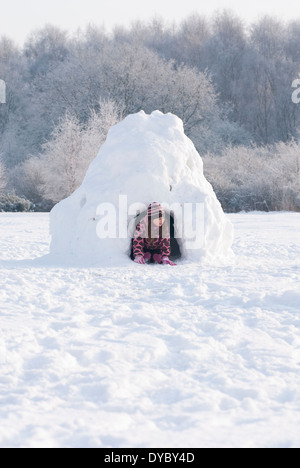 Kleines Mädchen versteckt in einem Iglu. Stockfoto