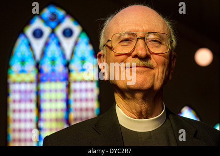Pastor in der Kirche mit Glasfenster Stockfoto