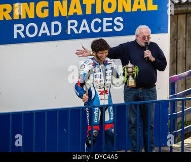 Olivers Mount Rennstrecke, Scarborough, England. 13. April 2014. TV Guy Martin mit der Trophäe stehen neben Kommentator Tony Coupland. Guy, Moderatorin von "Geschwindigkeit mit Guy Martin", "Wie Großbritannien gearbeitet" und "The Boot, dass Guy gebaut" fuhr seine 600er Suzuki GSXR zum Sieg in der Ian Watson Spring Cup, die erste Runde der UK National Road Race Championships. Für den Fall, dass er starke Herausforderungen um Sieg über drei Sekunden vom zweiten Platz Ivan Lintin abzuwehren. Bildnachweis: Ian Wray/Alamy Live-Nachrichten Stockfoto