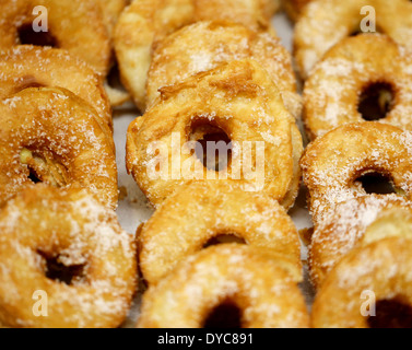 Runde Krapfen, bestreut mit weißem Pulver, verpackt in einer Reihe auf das Fenster Stockfoto