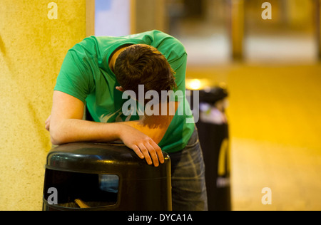 Ein betrunkener latscht auf einem Lagerplatz nach einer durchzechten Nacht "Binge drinking". Stockfoto