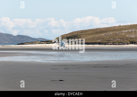 Eine de Havilland DHC-6 Twin Otter Ebene der Flybe - Loganair ausziehen aus der Strand Landebahn auf Isle of Barra, äußeren Hebriden. Stockfoto