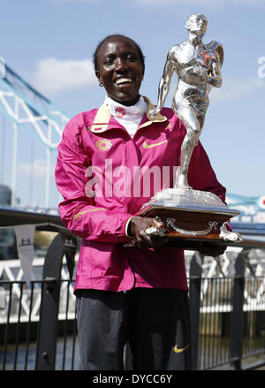 London, UK. 14. April 2014. Edna Kiplagat Kenia stellt mit ihrer Trophäe während der Champions Photocall 2014 London Marathon in der Nähe von Tower Bridge in London, England am 14. April 2014. Edna Kiplagat beansprucht den Titel der Elite Frauen mit 02:20:21 am letzten Sonntag. Bildnachweis: Wang Lili/Xinhua/Alamy Live-Nachrichten Stockfoto