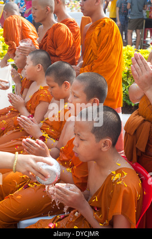 Bangkok, Thailand - Mönche Thai Neujahr Songkran Festival feiert Anfänger Mönch Novizen lustral Wasser gießen. Stockfoto