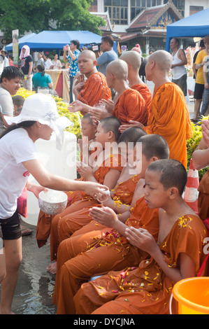 Bangkok, Thailand - Mönche Thai Neujahr Songkran Festival feiert Anfänger Mönch Novizen lustral Wasser gießen. Stockfoto