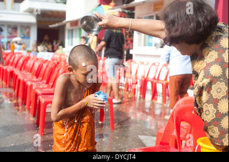 Bangkok, Thailand - Thai Neujahr, Frau Lustralwater auf dem Kopf ein Novize gießen Stockfoto