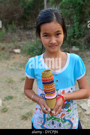 Das junge kamboische Mädchen bietet ihren gewebten Armbändern und Ringen.Schmuck zum Verkauf an Passagiere aus dem Bamboo Train O SRA Lav Dorf, Kambodscha Stockfoto