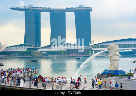 Touristen am Merlion Brunnen direkt vor dem Hotel Marina Bay Sands in Singapur. Stockfoto