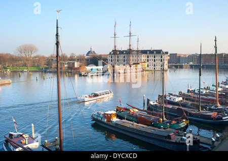 Wasser-Ausflug mit dem Fluss Amstel in Amsterdam, Niederlande. National Maritime Museum im Hintergrund Stockfoto