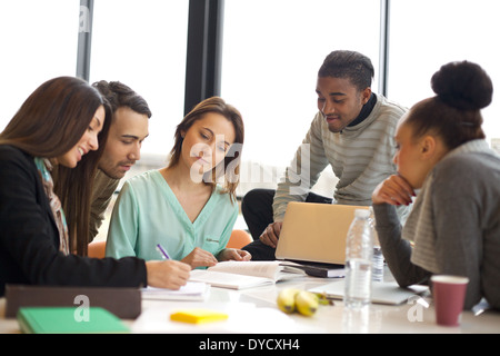 Heterogene Gruppe von jungen Studenten gemeinsam an Schulaufgaben. Multiethnische Leute studieren zusammen an einem Tisch. Stockfoto