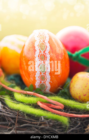 Orange dekorative Ei mit Bändern und Spitzen Drum und dran in Vogel nest zu Ostern Stockfoto