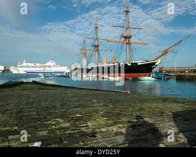 HMS Warrior mit einer Bretagne-Fähre verlässt Portsmouth Harbout im Hintergrund, die Hard, Portsmouth, England entnommen Stockfoto