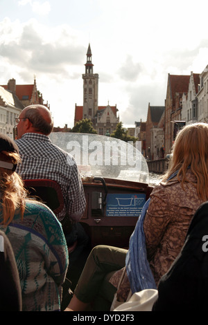 Touristen auf eine Freude Kreuzfahrt auf dem Kanal mit der Portierloge im Hintergrund, Brügge, Belgien Stockfoto