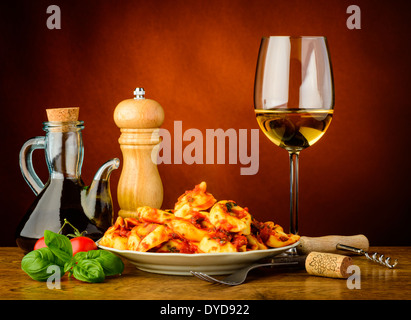 Stillleben mit traditionellen Tortellini Nudeln Essen und ein Glas Weißwein Stockfoto