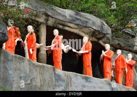 Figuren der buddhistischen Mönche vor einem Felsen Nische im Goldenen Tempel, Dambulla, Central Province, Sri Lanka Stockfoto