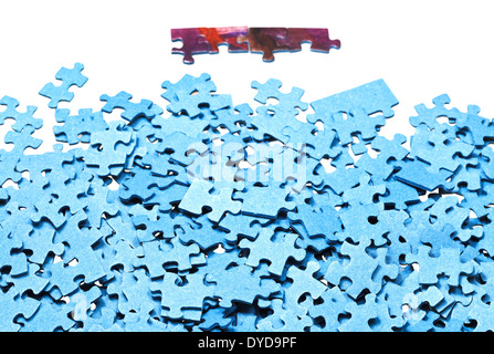 einige angeschlossene Stücke in der Nähe von Haufen von Puzzles isoliert auf weißem Hintergrund Stockfoto