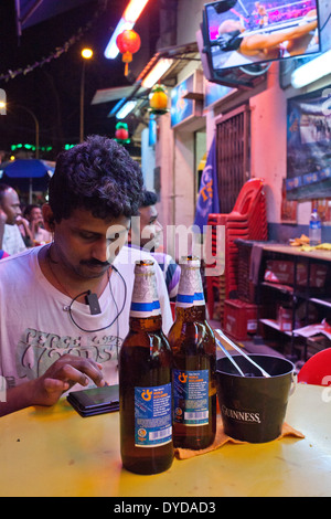 Wanderarbeiter in Little India an einem Sonntag Abend entspannen. Singapur Stockfoto