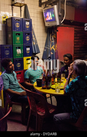 Wanderarbeiter in Little India an einem Sonntag Abend entspannen. Singapur Stockfoto