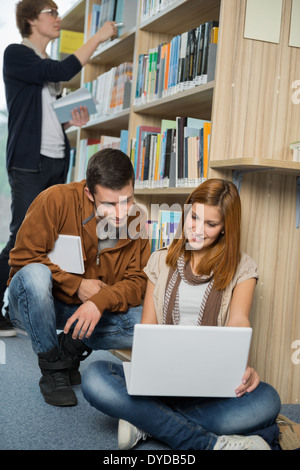Junge College-Freunde, die gemeinsam auf Laptop in der Bibliothek studieren Stockfoto