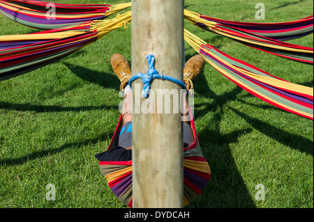 Ein Mann schlafen in einer Hängematte auf dem Brownstock Festival in Essex. Stockfoto