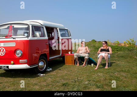 Ein junges Paar, camping in einem VW Campervan auf die rührende über Mundesley an der Küste von Norfolk. Stockfoto