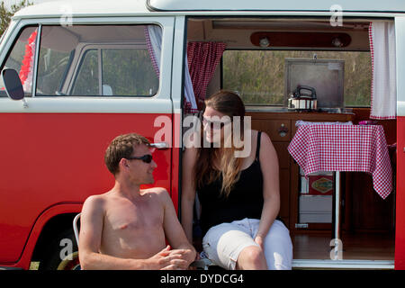 Ein junges Paar, camping in einem VW Campervan auf die rührende über Mundesley an der Küste von Norfolk. Stockfoto