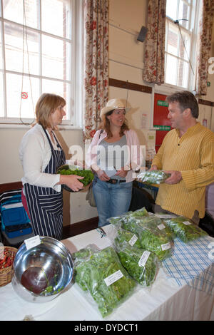 Kunden im Gespräch mit einer Stall-Inhaber auf einem Bauernmarkt in Norfolk. Stockfoto