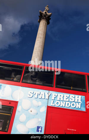 Ein roter Londoner Bus geht die Nelsonsäule. Stockfoto