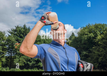 Männliche Radfahrer trinken aus einer Flasche Wasser. Stockfoto