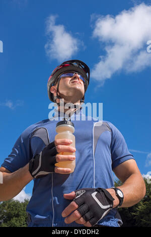 Männliche Radfahrer trinken aus einer Flasche Wasser. Stockfoto