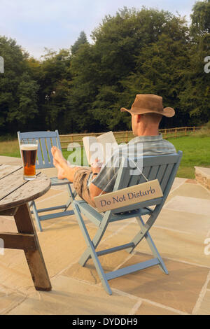 Ein Mann mit einem Buch und Glas Bier entspannen. Stockfoto