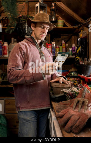 Mann mit einem Paket von Samen in seinem Gartenhaus. Stockfoto