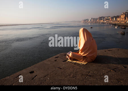 Ein Sadhu liest auf den Ghats. Stockfoto