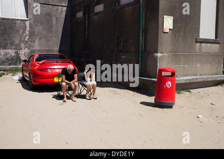 Paar mit ihrem Auto am Strand. Stockfoto