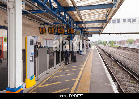 Passagiere warten auf einen Zug auf einem Bahnsteig. Stockfoto