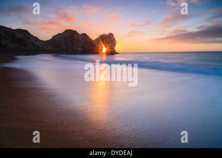 Die Sonne durch den Bogen bei Durdle Door. Stockfoto