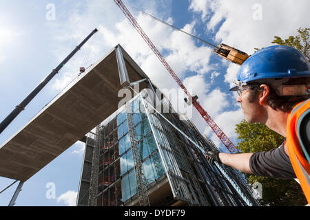 Betreiber mit Seilen, Aufzug Kran auf einer Baustelle zu führen. Stockfoto