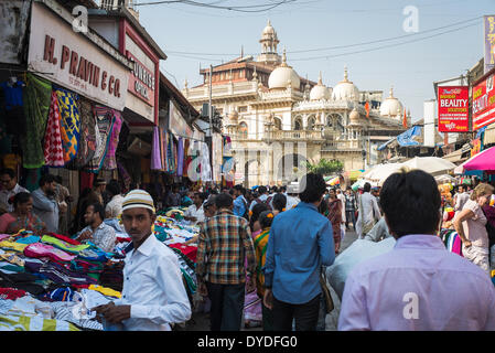 Ein junger Muslim in einem Straßenmarkt mit Verkaufsständen Kleidung vor einer großen Moschee. Stockfoto