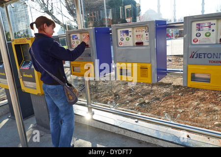 Eine Frau kauft ein Ticket von einem Rechner für eine Straßenbahn in Istanbul, Türkei. Stockfoto