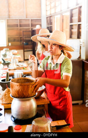 Ein Tutor Unterweisung wie man Klebreis in Thai Farm Cooking School in Chiang Mai in Thailand machen. Stockfoto