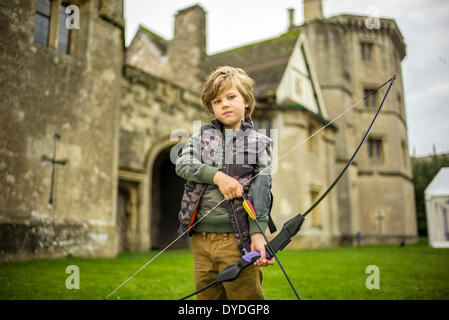 Ein kleiner Junge in Thornbury Castle Garden spielen Bogenschießen. Stockfoto