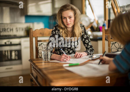 Ein 16 Jahre altes Mädchen Mathe Hausaufgaben auf dem Küchentisch. Stockfoto