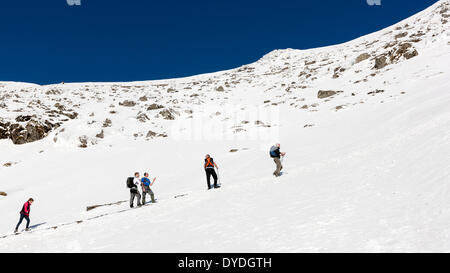 Eine Gruppe von Menschen steigt die verschneiten Pyg Track in Snowdonia-Nationalpark. Stockfoto