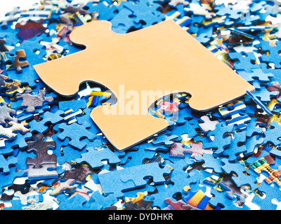 ein großes Stück auf Haufen von zerlegten kleine blaue puzzles Stockfoto